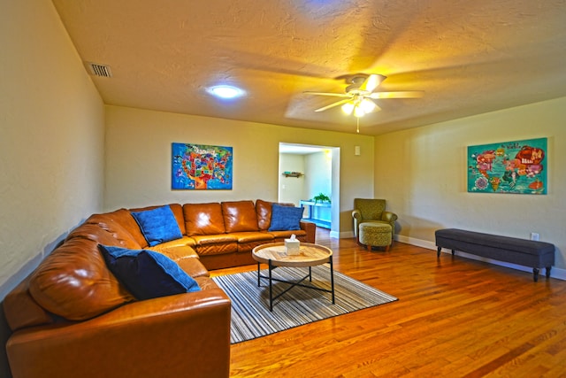 living room with wood-type flooring and ceiling fan