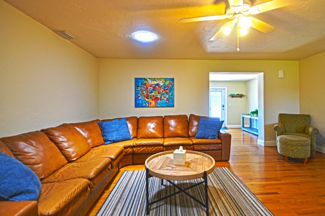 living room featuring hardwood / wood-style floors and ceiling fan