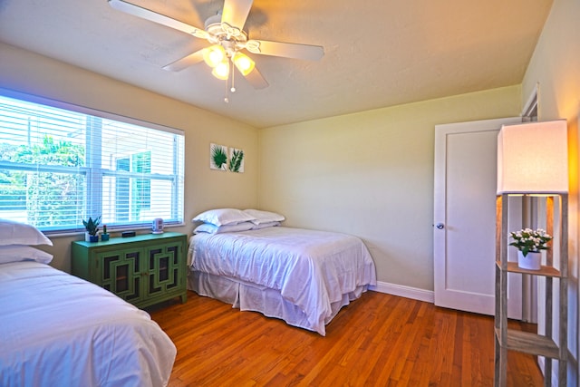 bedroom with ceiling fan and dark wood-type flooring