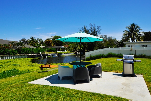 view of patio with grilling area and a water view