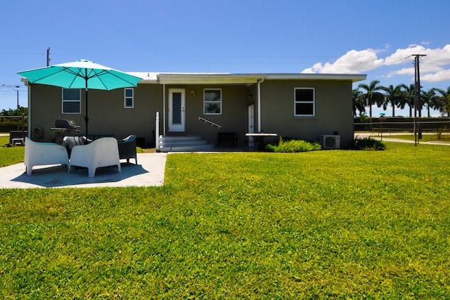 rear view of property with central AC unit, a patio, and a lawn