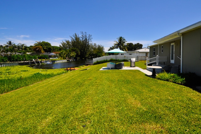 view of yard with a water view and a patio area