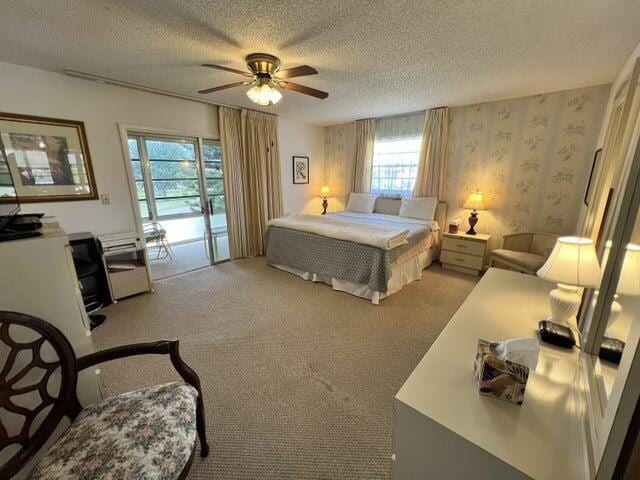 bedroom with ceiling fan, light carpet, access to exterior, and a textured ceiling