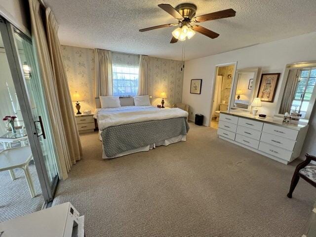 bedroom featuring ceiling fan, a textured ceiling, and light colored carpet