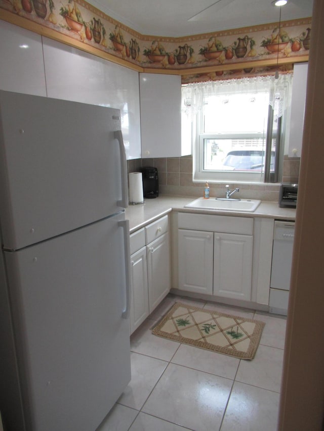 kitchen with light tile patterned flooring, sink, white cabinetry, tasteful backsplash, and white appliances