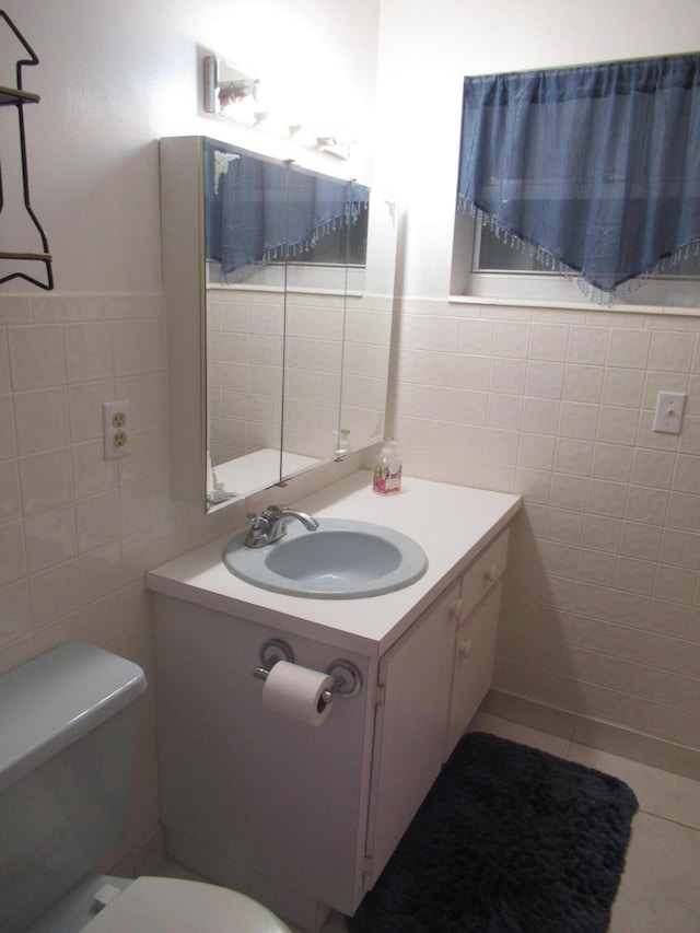 bathroom featuring vanity, toilet, and tile walls