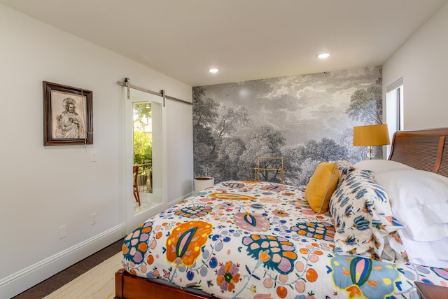 bedroom with multiple windows, a barn door, and dark wood-type flooring