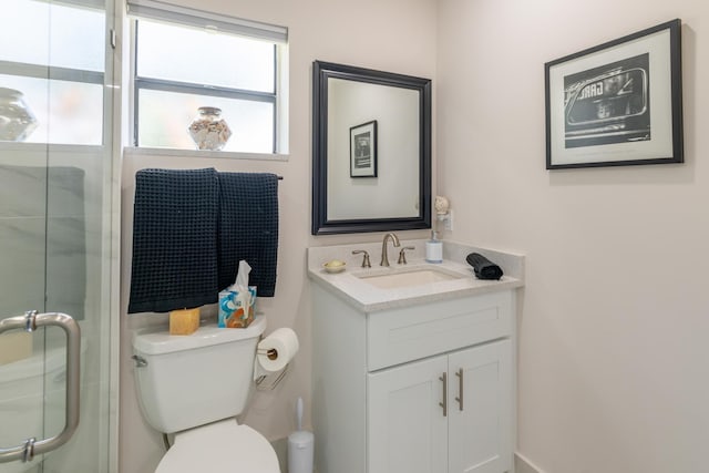 bathroom featuring vanity, an enclosed shower, and toilet