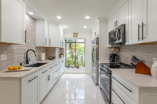 kitchen featuring sink, tasteful backsplash, light tile patterned floors, stainless steel appliances, and white cabinets