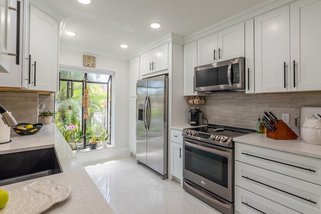 3593 Crab Apple Trl Unit C, Lake Worth, FL 33467 - kitchen with appliances with stainless steel finishes, light tile patterned flooring, white cabinets, crown molding, and recessed lighting