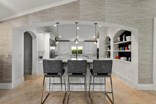 kitchen featuring light tile patterned floors, crown molding, and white cabinetry