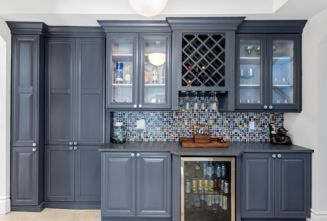 bar with gray cabinetry, tasteful backsplash, and beverage cooler