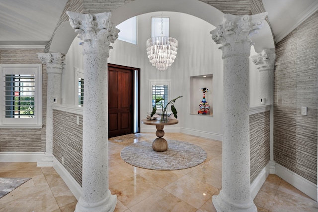 tiled entrance foyer with a chandelier and ornate columns