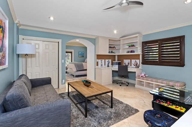 living room with ceiling fan, light tile patterned floors, built in desk, and crown molding