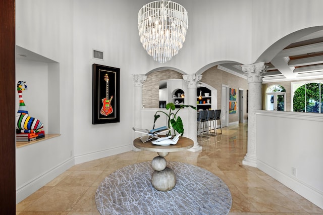 tiled entryway featuring coffered ceiling, crown molding, a notable chandelier, ornate columns, and beamed ceiling