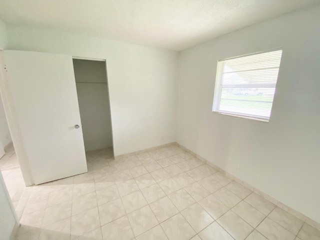 unfurnished bedroom featuring light tile patterned flooring and a closet