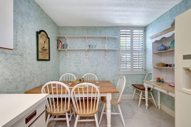 dining area with a textured ceiling and light tile patterned floors