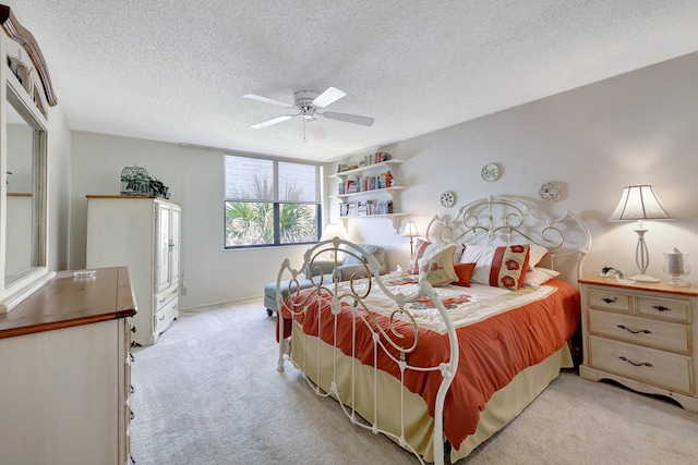 bedroom with a textured ceiling, light colored carpet, and ceiling fan