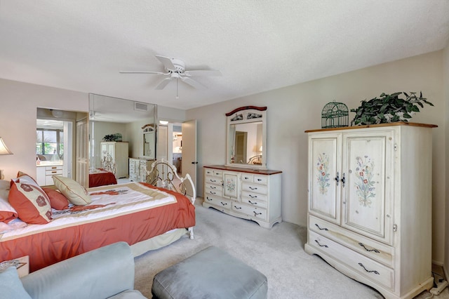 bedroom with light carpet, a textured ceiling, and ceiling fan