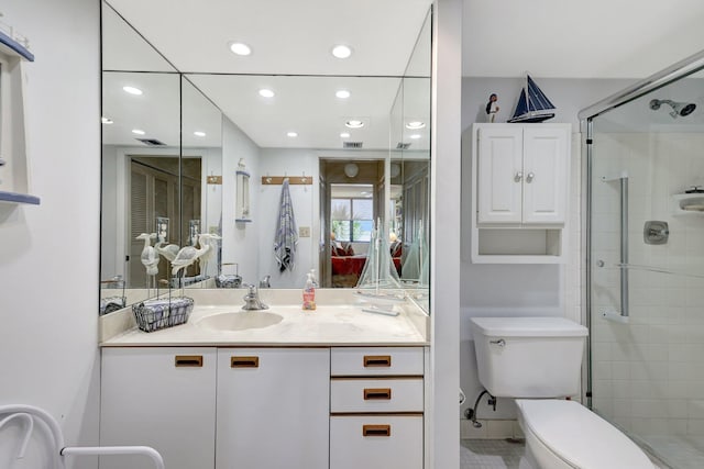 bathroom with a shower with shower door, vanity, and toilet