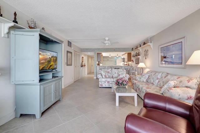 tiled living room with ceiling fan and a textured ceiling