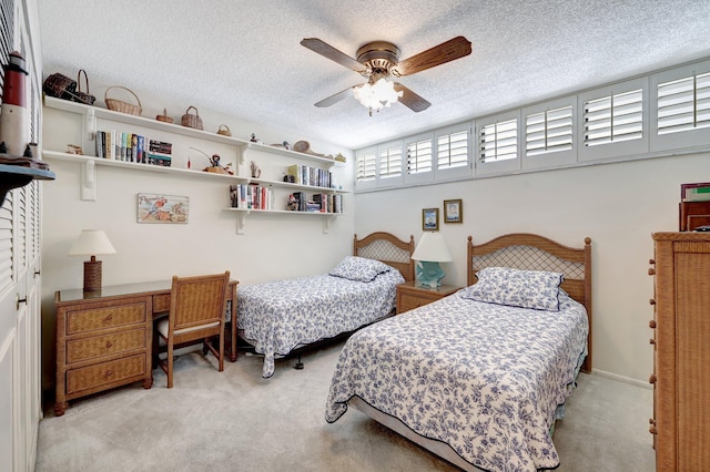 bedroom with light carpet, a textured ceiling, and ceiling fan