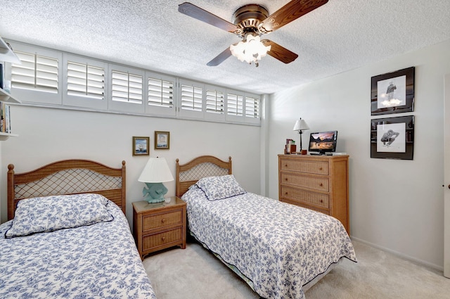 carpeted bedroom featuring a textured ceiling and ceiling fan