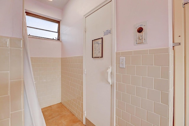 bathroom with tile patterned flooring and tile walls