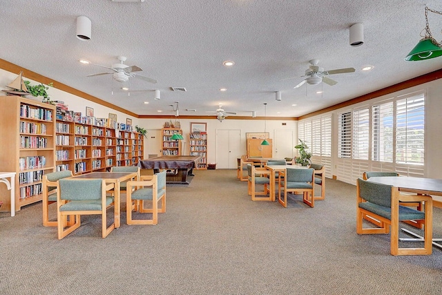 recreation room with light colored carpet, a textured ceiling, ceiling fan, ornamental molding, and billiards