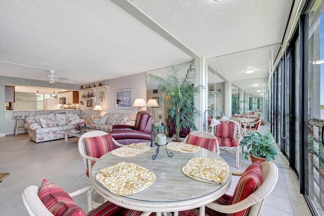 dining room featuring a textured ceiling, light tile patterned floors, and ceiling fan