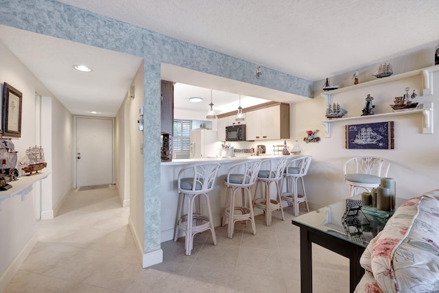 interior space featuring light tile patterned flooring and a textured ceiling