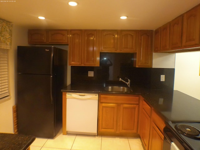 kitchen with black refrigerator, sink, backsplash, dishwasher, and light tile patterned floors