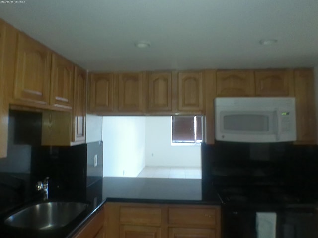 9872 Marina Blvd Unit 1434, Boca Raton, FL 33433 - kitchen with white microwave, light brown cabinets, and dark countertops