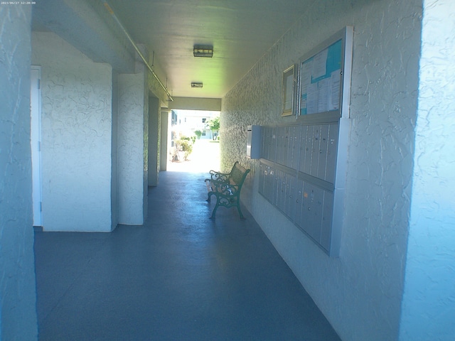 hallway featuring a mail area and concrete flooring