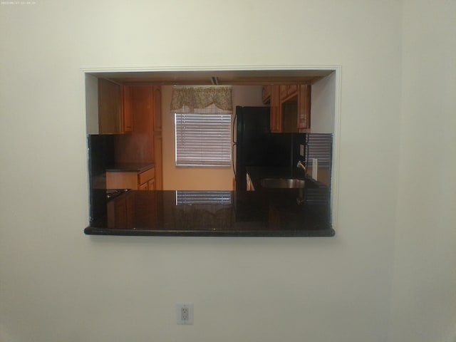 kitchen featuring black refrigerator, sink, and kitchen peninsula