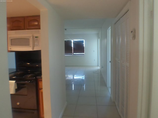 hall featuring light tile patterned floors