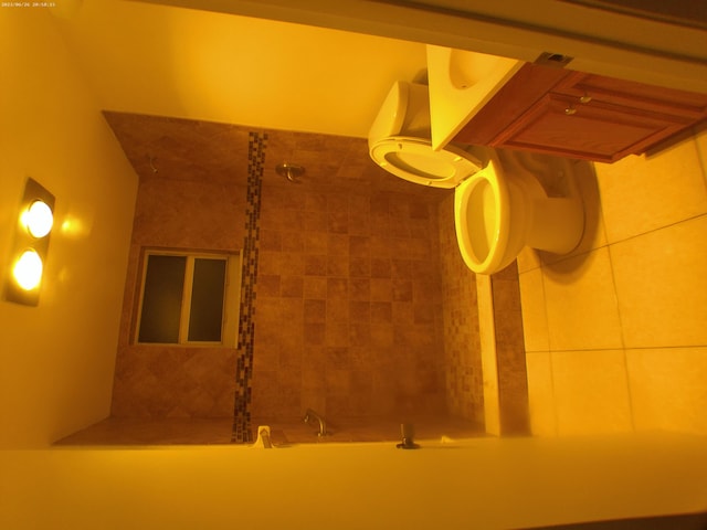 interior space with tiled shower / bath combo and toilet