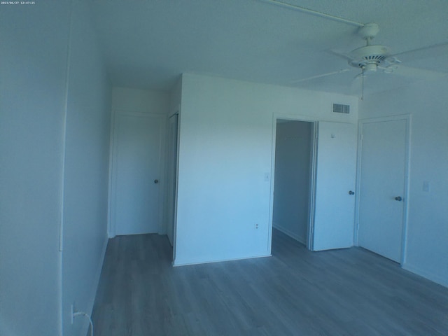 unfurnished bedroom featuring ceiling fan, wood-type flooring, and a closet