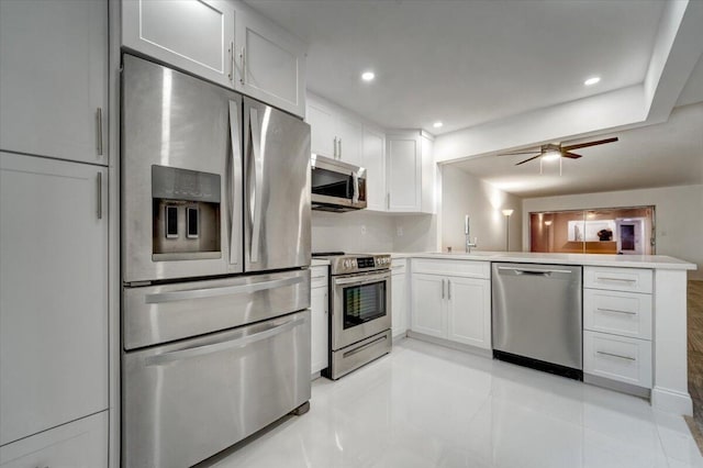 3601 Inverrary Dr Unit 102, Lauderhill, FL 33319 - kitchen with stainless steel appliances, a peninsula, a sink, white cabinetry, and a ceiling fan