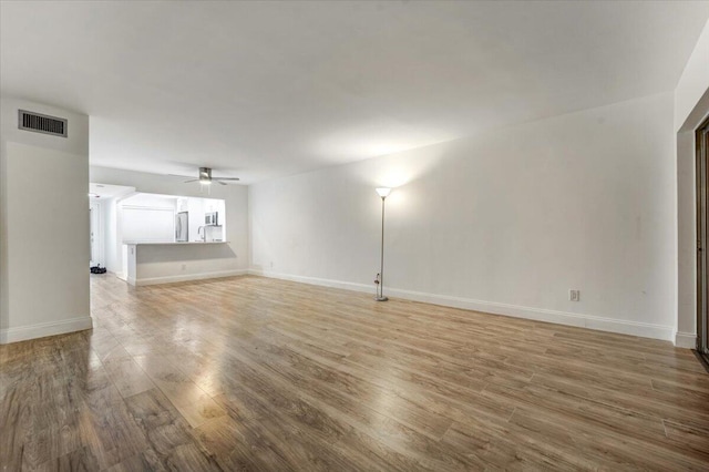 3601 Inverrary Dr Unit 102, Lauderhill, FL 33319 - unfurnished living room with a ceiling fan, light wood-type flooring, and baseboards