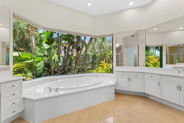 bathroom featuring independent shower and bath, plenty of natural light, and vanity