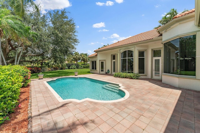 view of pool featuring a yard and a patio