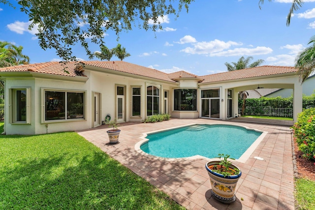 view of swimming pool featuring ceiling fan, a patio area, and a yard