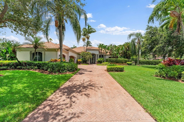 mediterranean / spanish home with a front lawn