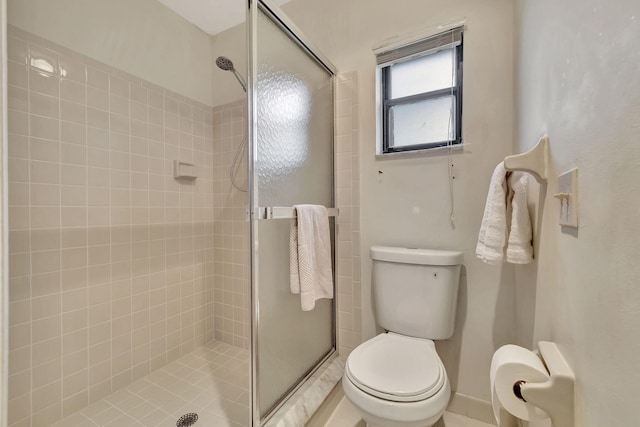 bathroom with tile patterned floors, a shower with shower door, and toilet