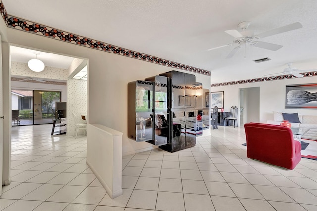 tiled living room with a textured ceiling and ceiling fan