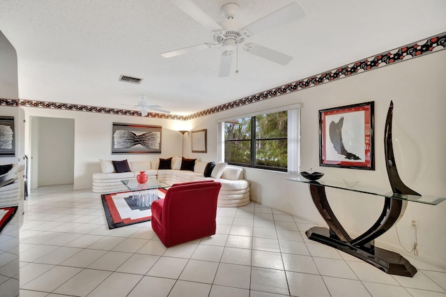 living room with light tile patterned flooring, a textured ceiling, and ceiling fan