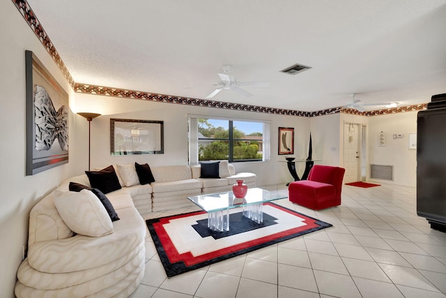 living room with a textured ceiling, light tile patterned flooring, and ceiling fan