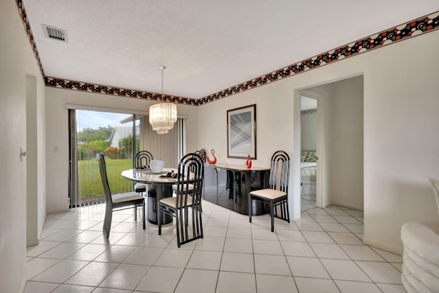 tiled dining space with a chandelier