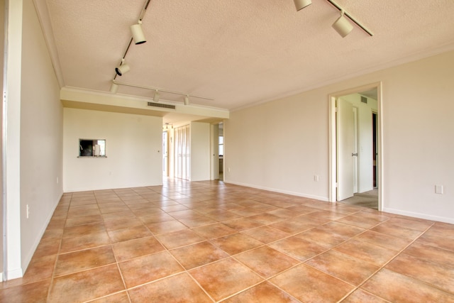 spare room featuring a textured ceiling, track lighting, and light tile patterned floors